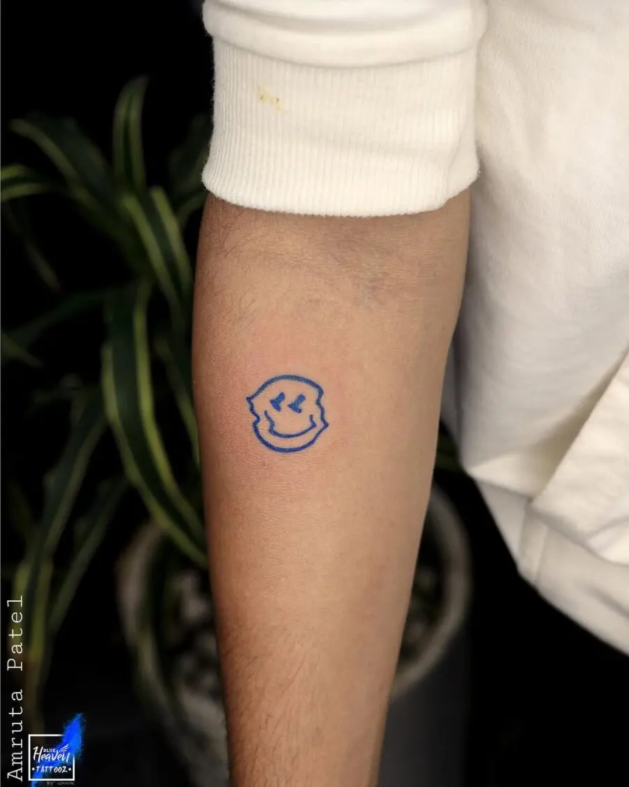 Charming blue smiley face tattoo on arm