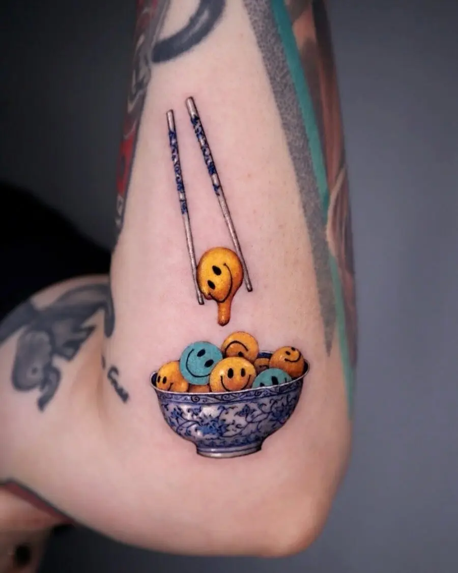 Playful smiley face tattoo with artistic flair