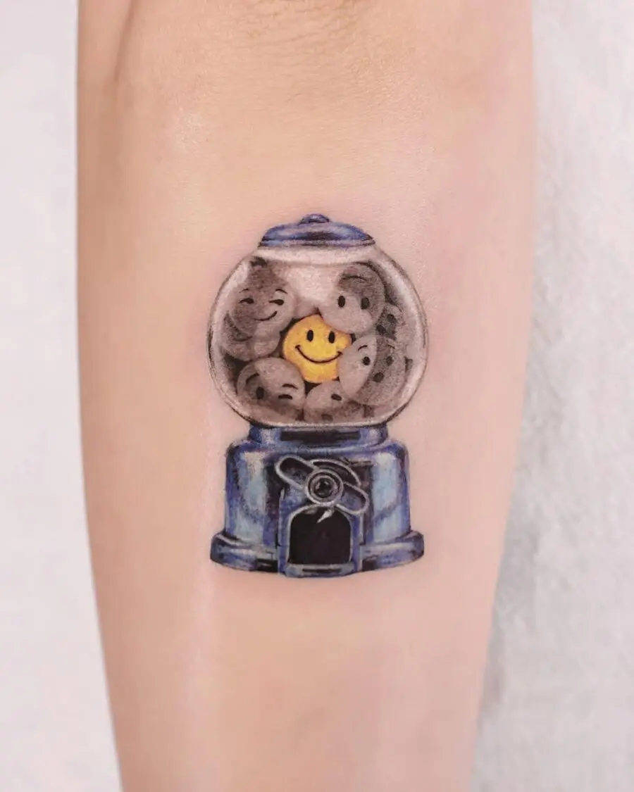 Playful smiley face gumball machine tattoo