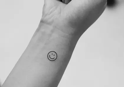 Charming minimalist smiley face tattoo on wrist