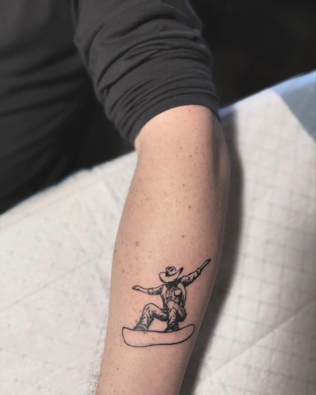 Cowboy-themed snowboard tattoo for adventurous spirits