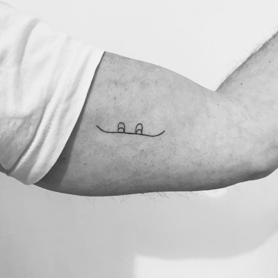 Minimalist snowboard tattoo design on forearm