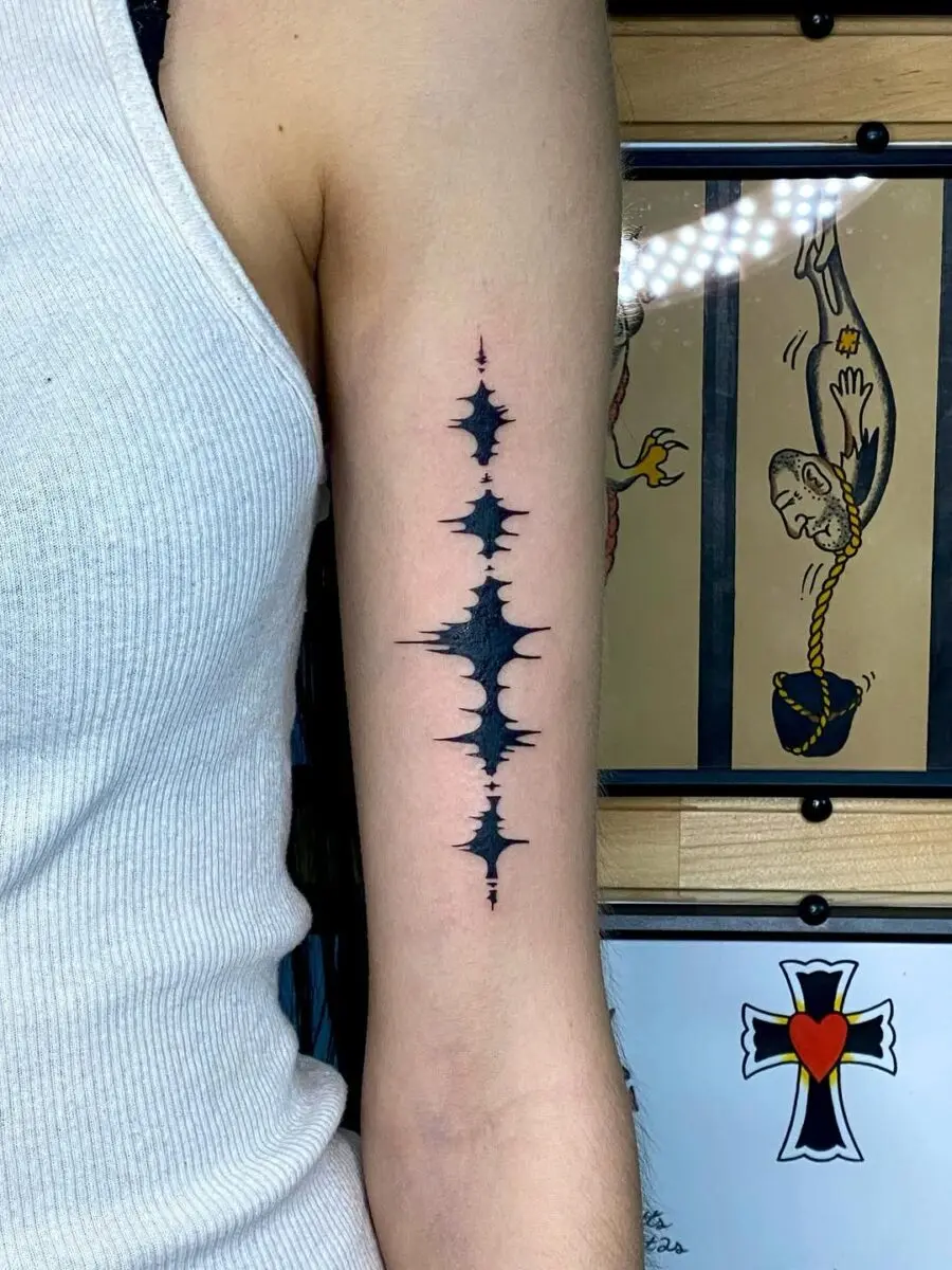 Intricate soundwave tattoo on forearm
