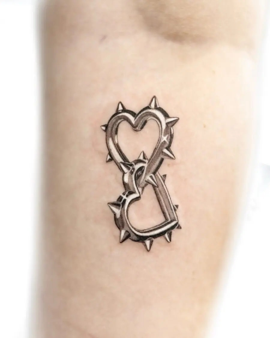 Stylish spiked heart tattoo in silver ink