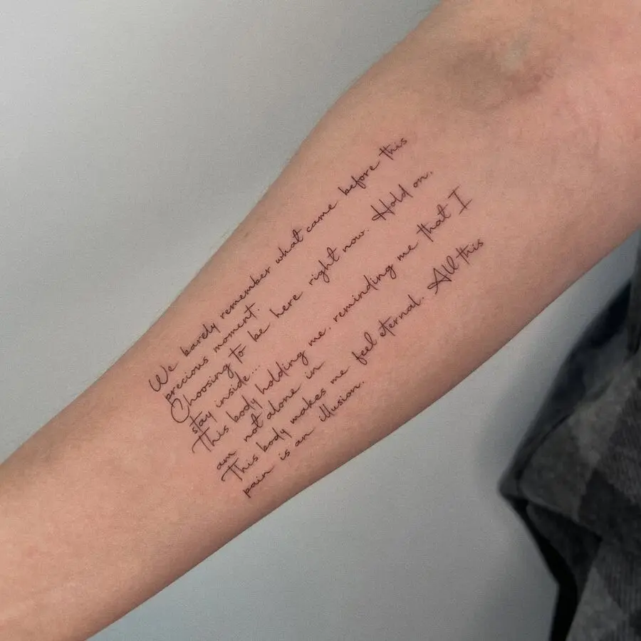 Elegant handwritten quote tattoo on forearm