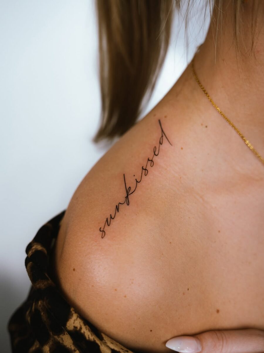 Sleek and elegant script tattoo on shoulder
