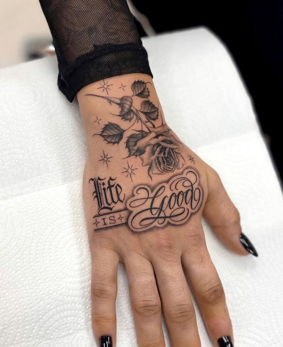 Elegant hand tattoo with rose and script