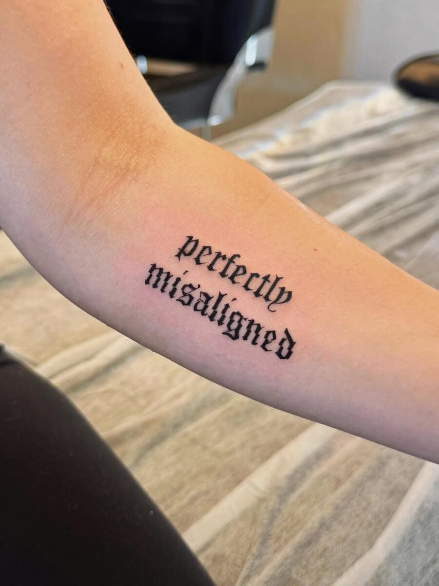 Bold script tattoo with unique flair