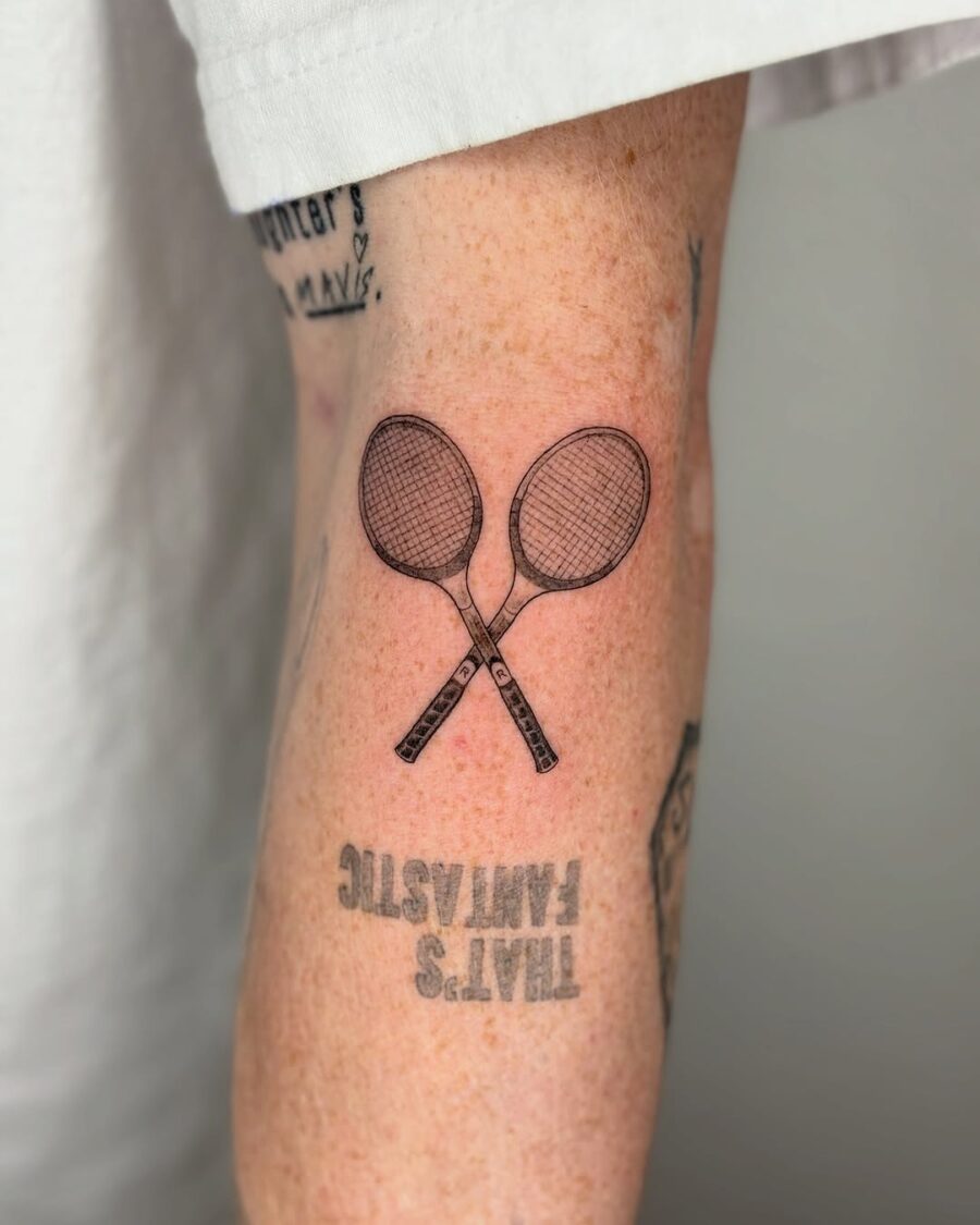 Stylish tennis rackets inked on the arm