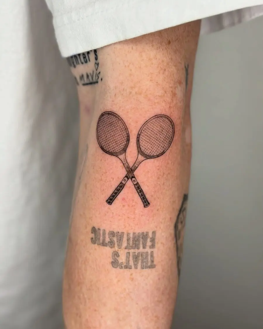 Stylish tennis rackets inked on the arm