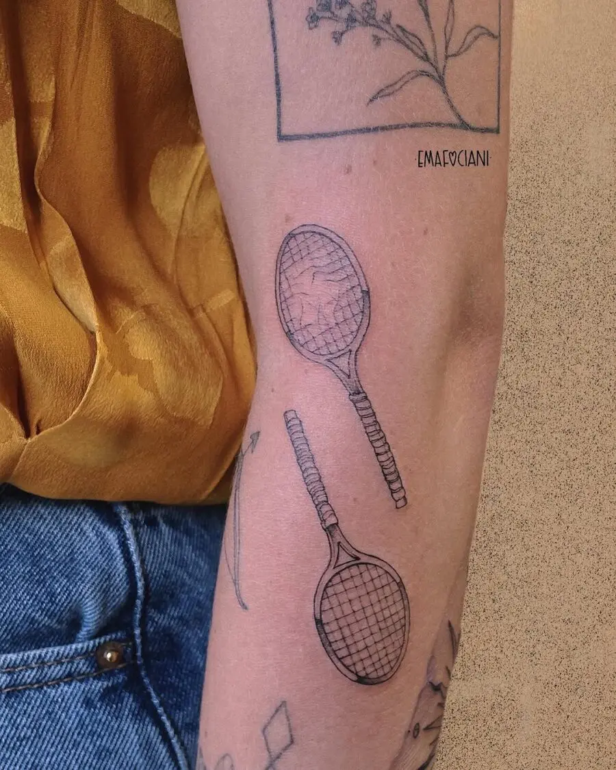 Stylish tennis rackets tattooed on arm