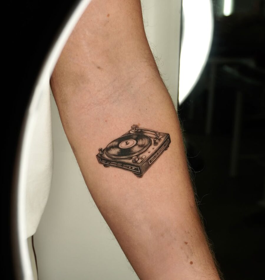 Sleek record player tattoo on forearm