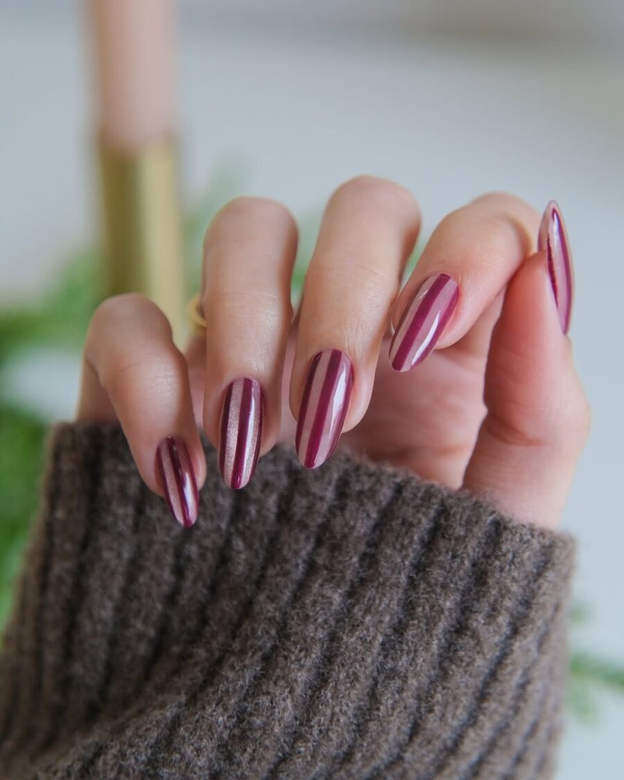 Elegant burgundy velvet nails with gold stripes