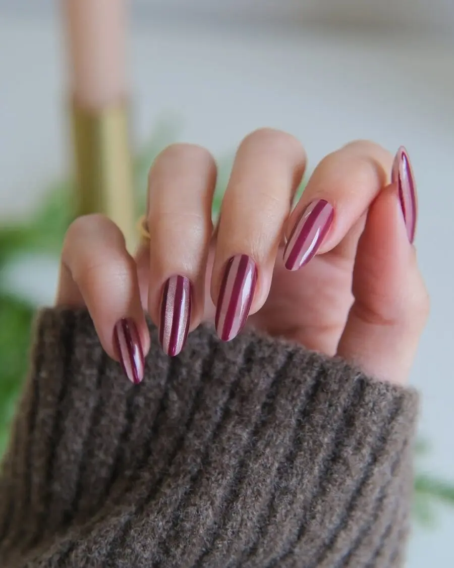 Elegant burgundy velvet nails with gold stripes