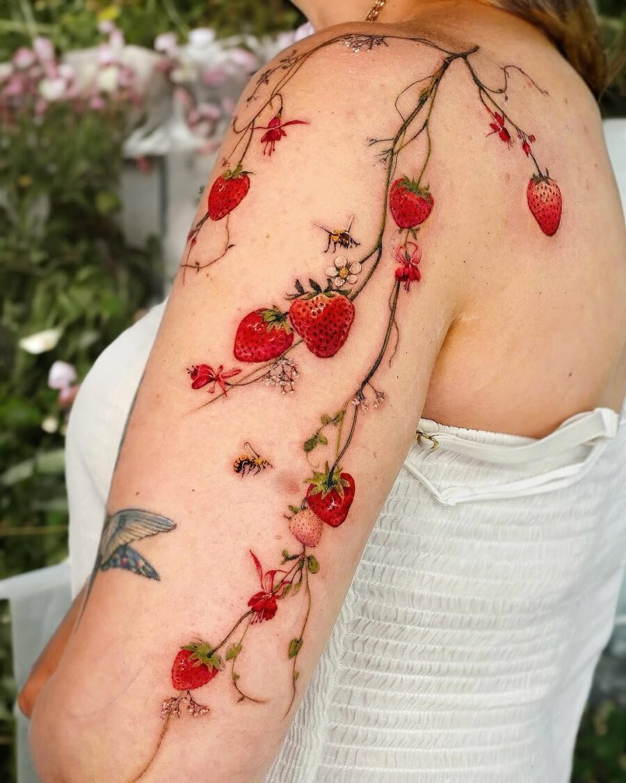Colorful strawberry tattoo with floral accents