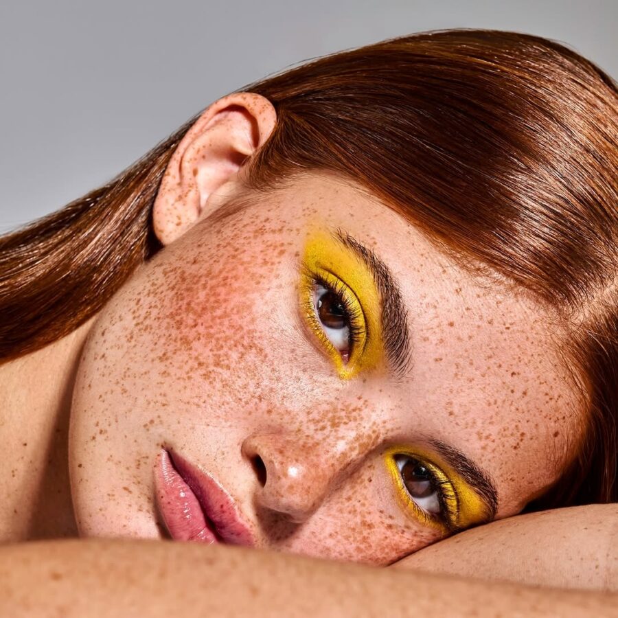 Bold yellow eyeshadow enhances natural beauty.