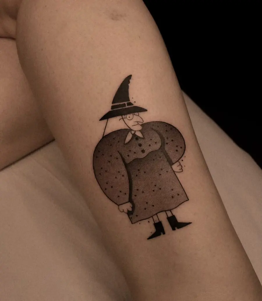 Playful cartoon witch hat tattoo on arm