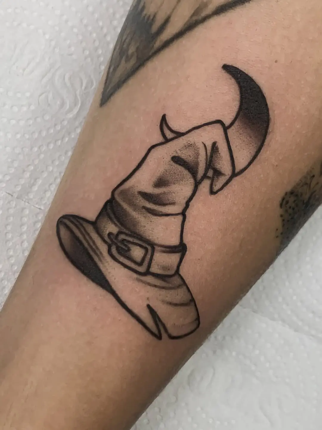Chic black witch hat tattoo with subtle shading