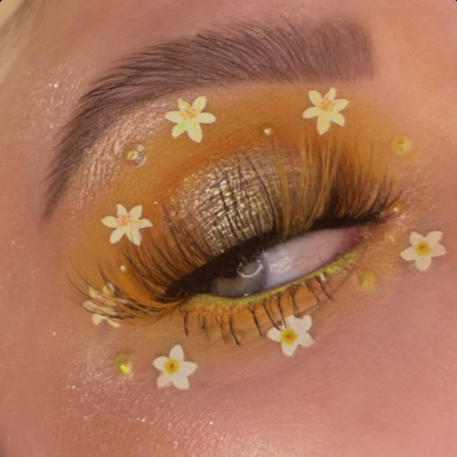 Vibrant yellow makeup with floral accents