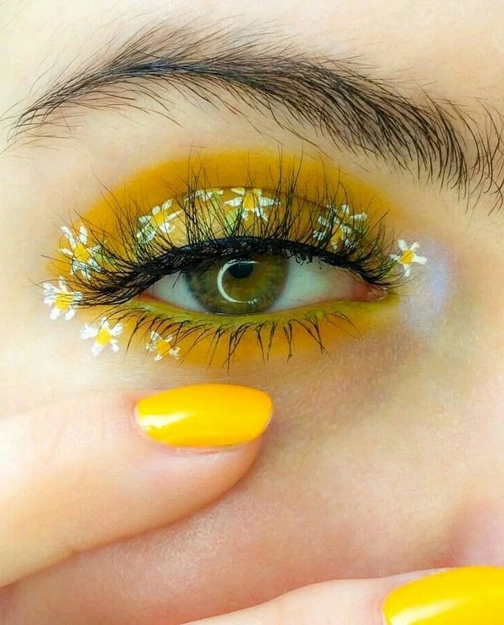 Vibrant yellow eye makeup with floral accents