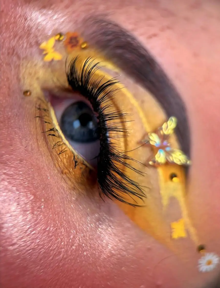 Vibrant yellow eye makeup with butterfly accents