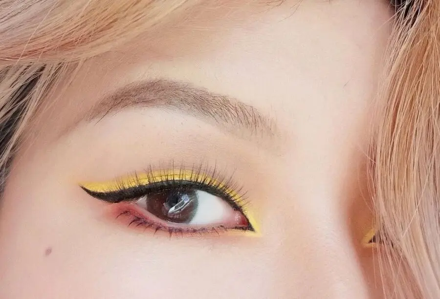 Vibrant yellow eyeliner with winged effect