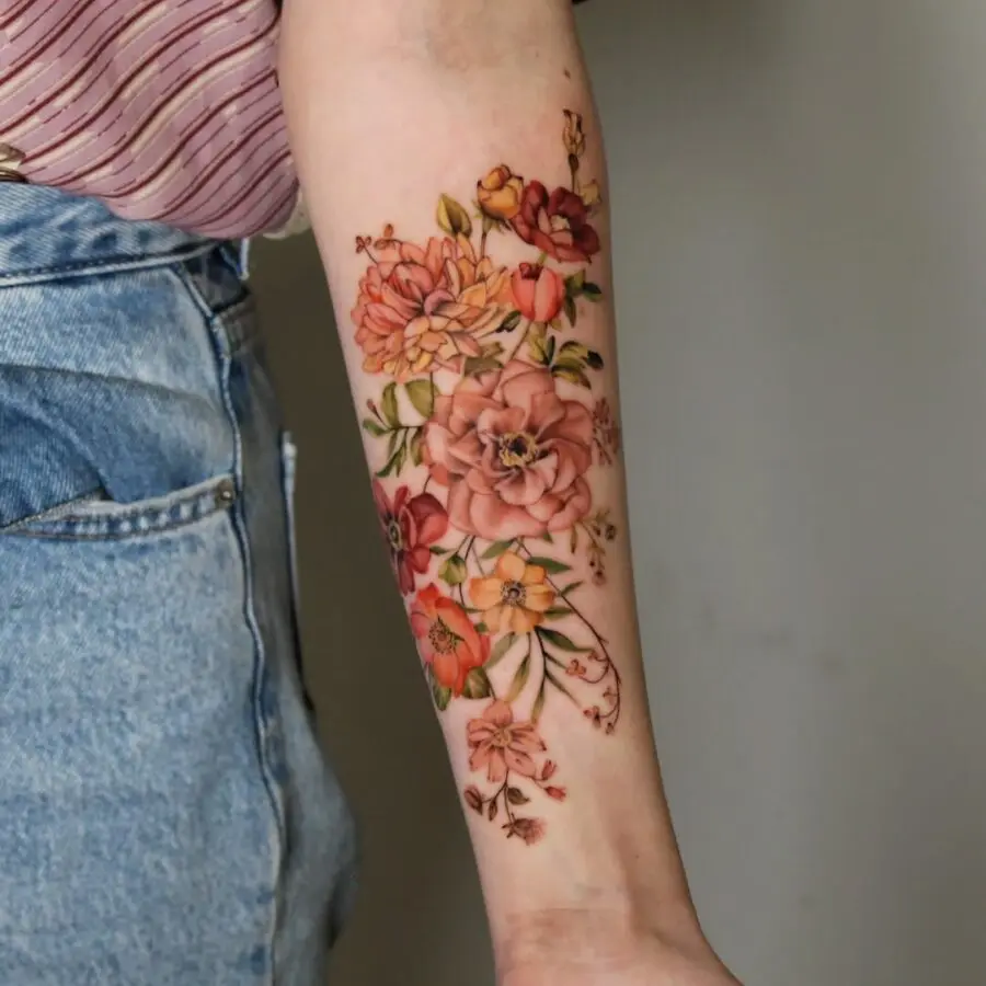 Elegant floral zinnia tattoo on forearm