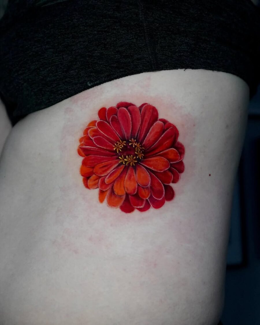 Striking red zinnia tattoo on the side