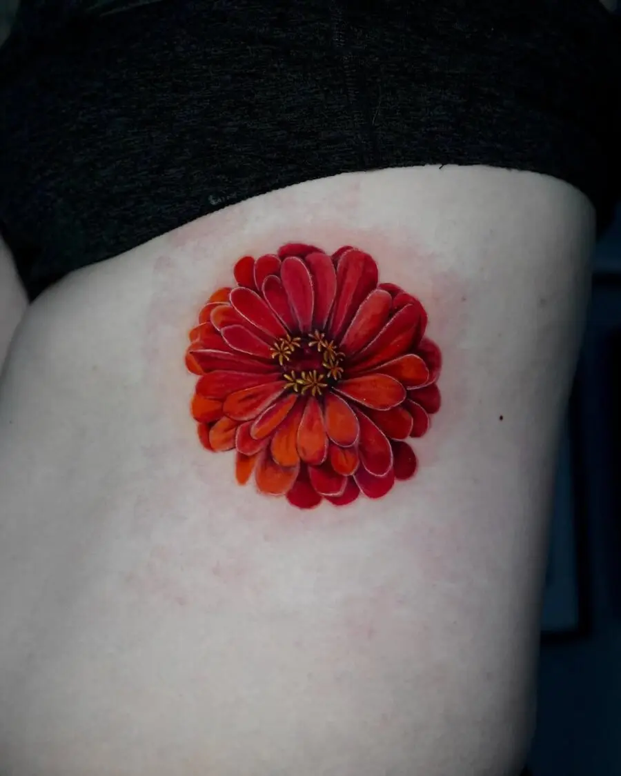 Striking red zinnia tattoo on the side