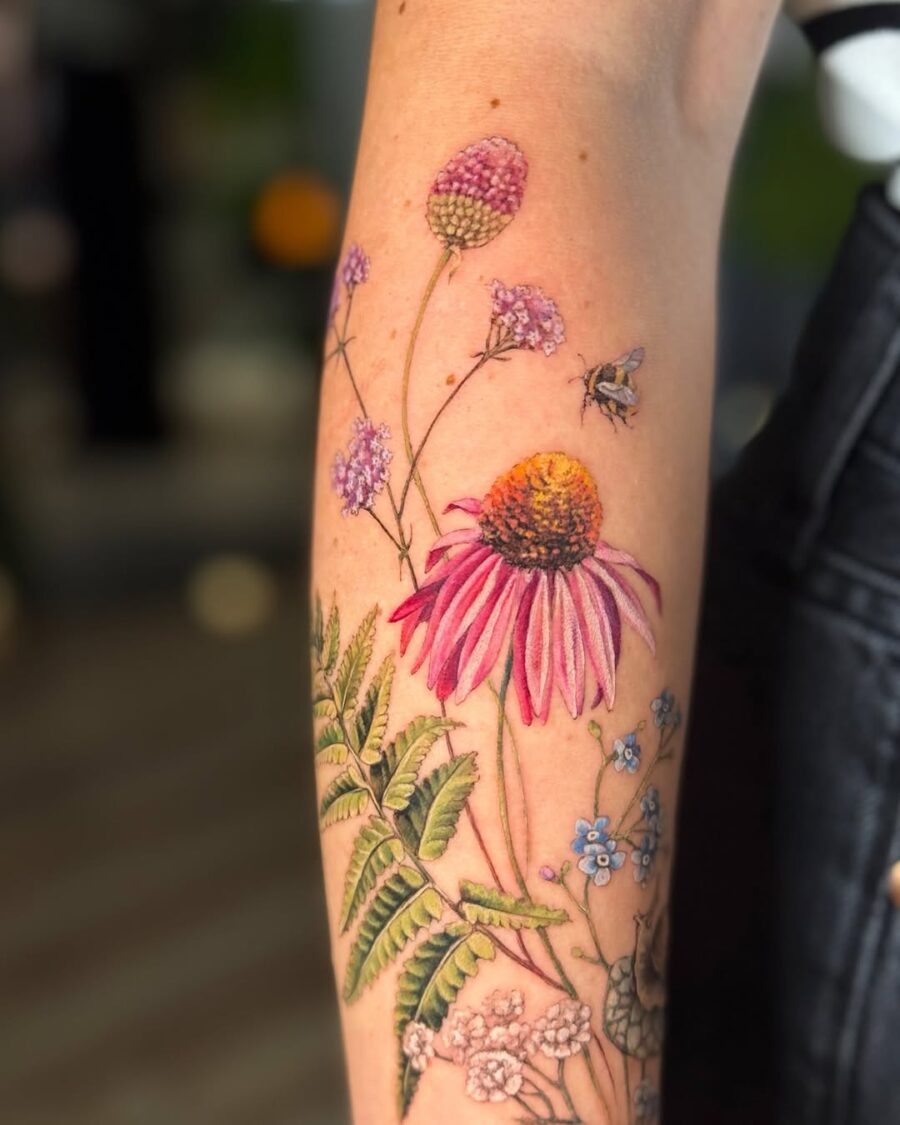 Vibrant zinnia tattoo with floral details