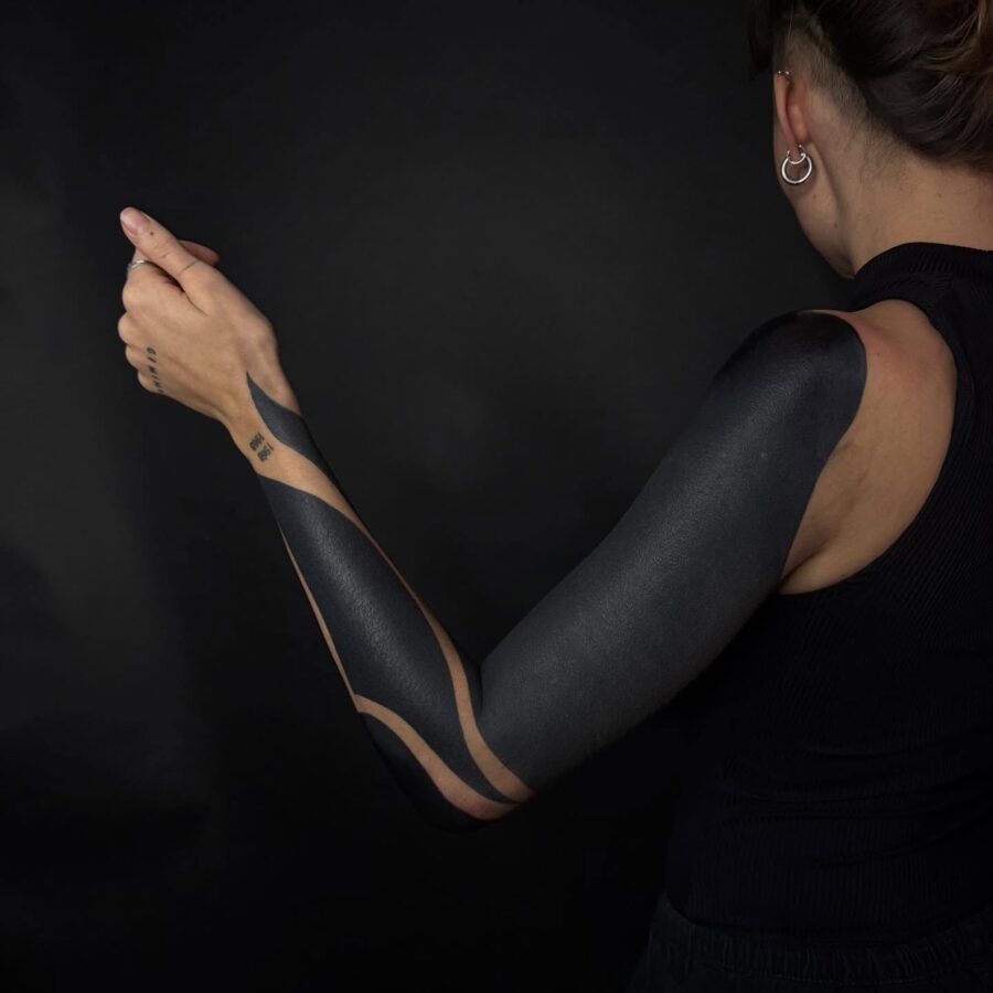 Bold black sleeve tattoo with abstract patterns