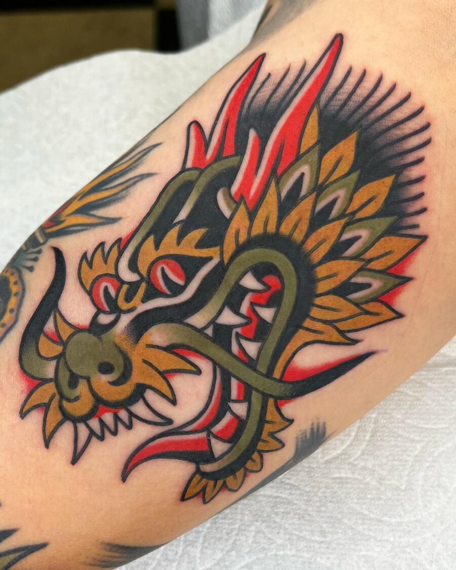 Bold dragon design on bicep tattoo