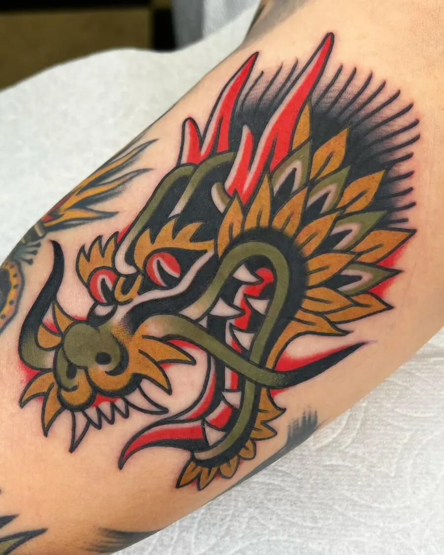 Bold dragon design on bicep tattoo