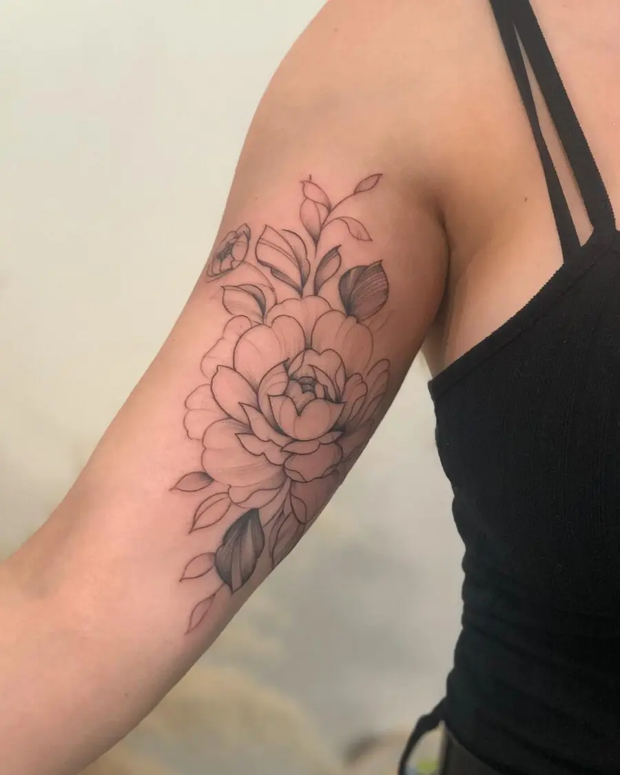 Elegant floral design on a bicep tattoo.