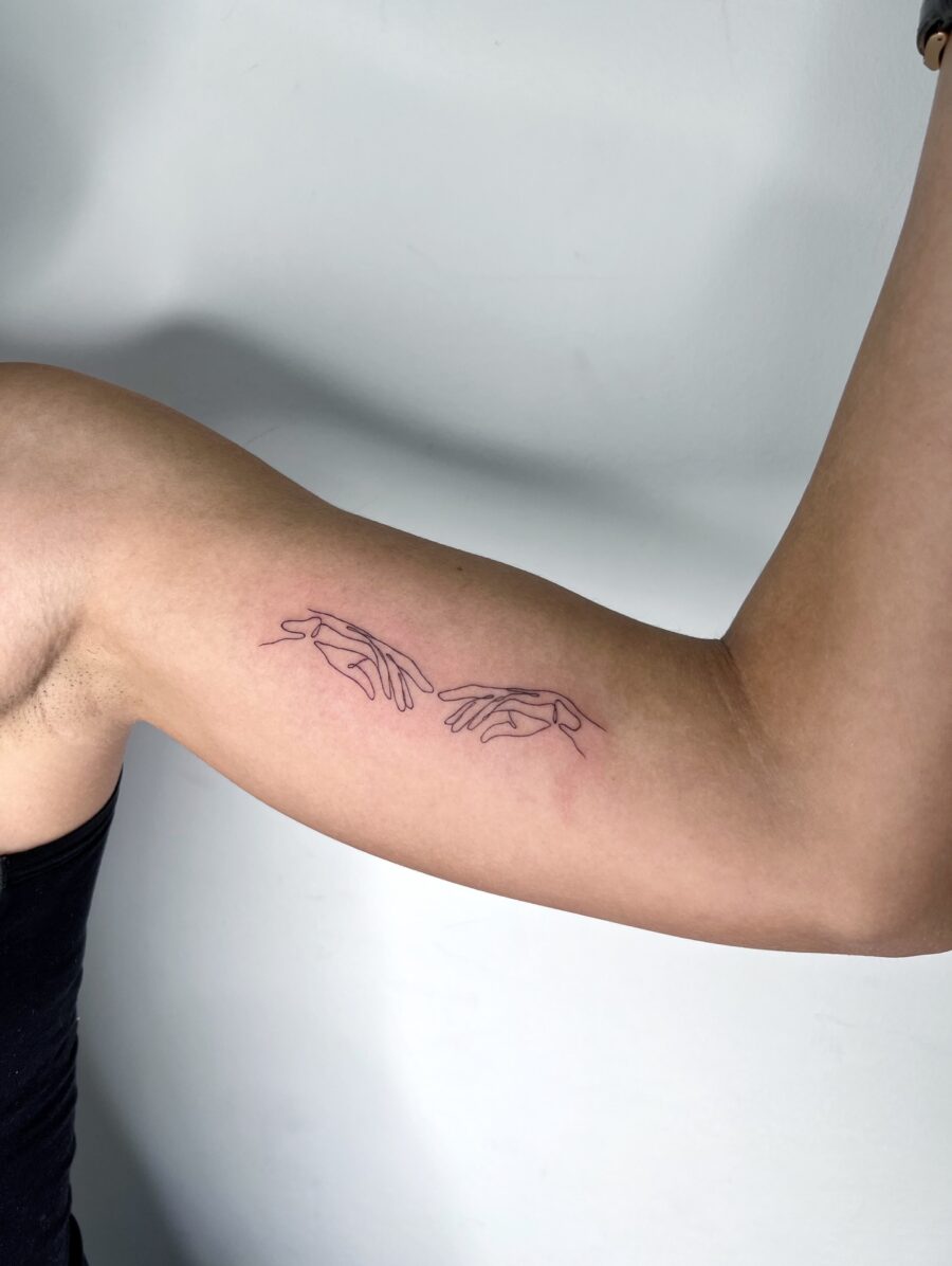 Minimalistic hands tattoo on biceps