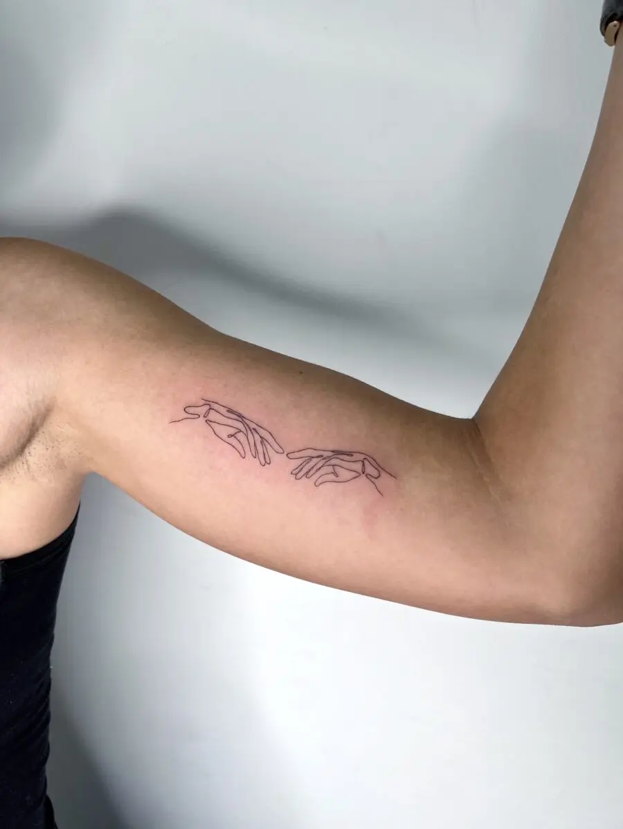 Minimalistic hands tattoo on biceps