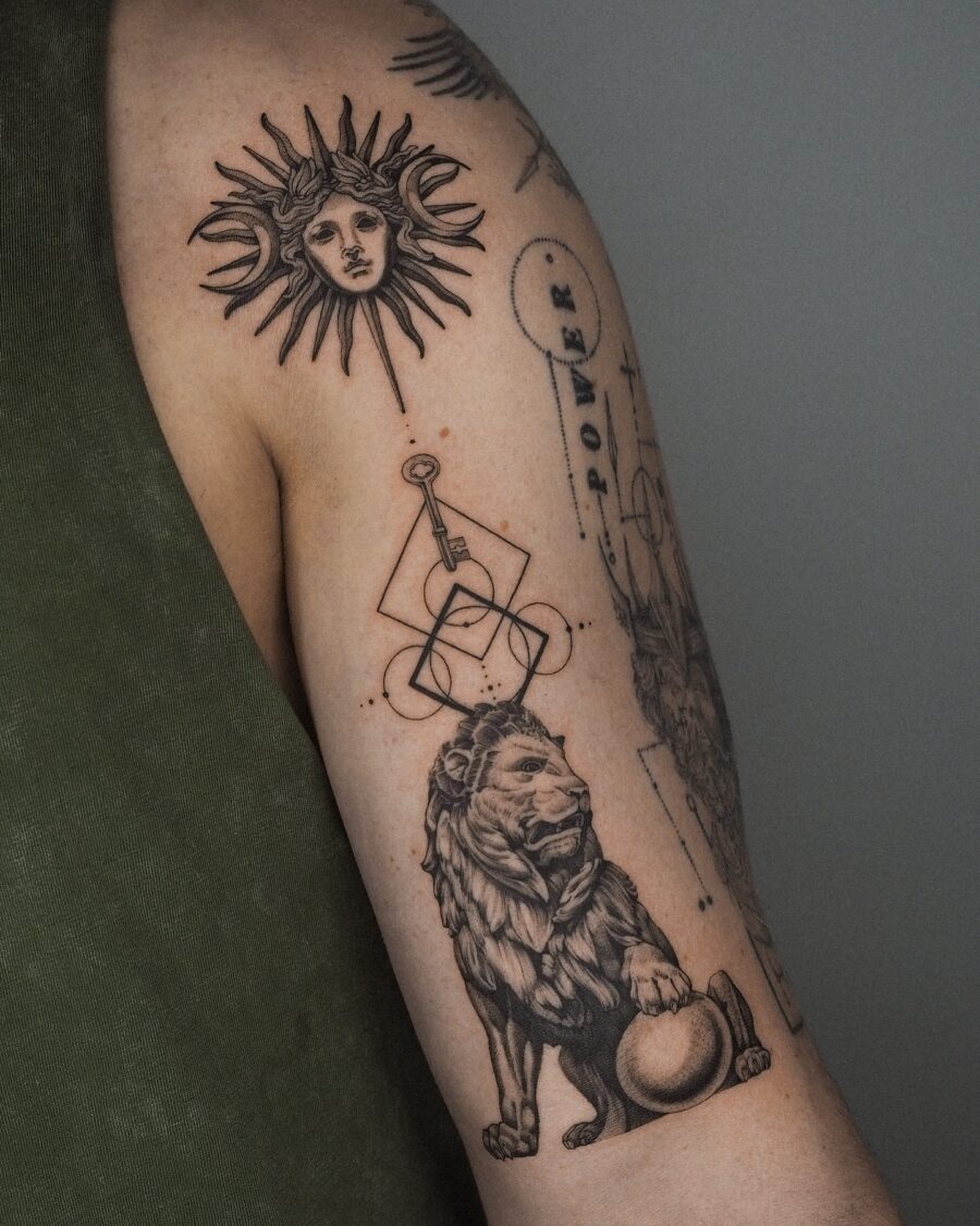 Symbolic biceps tattoo of sun and lion