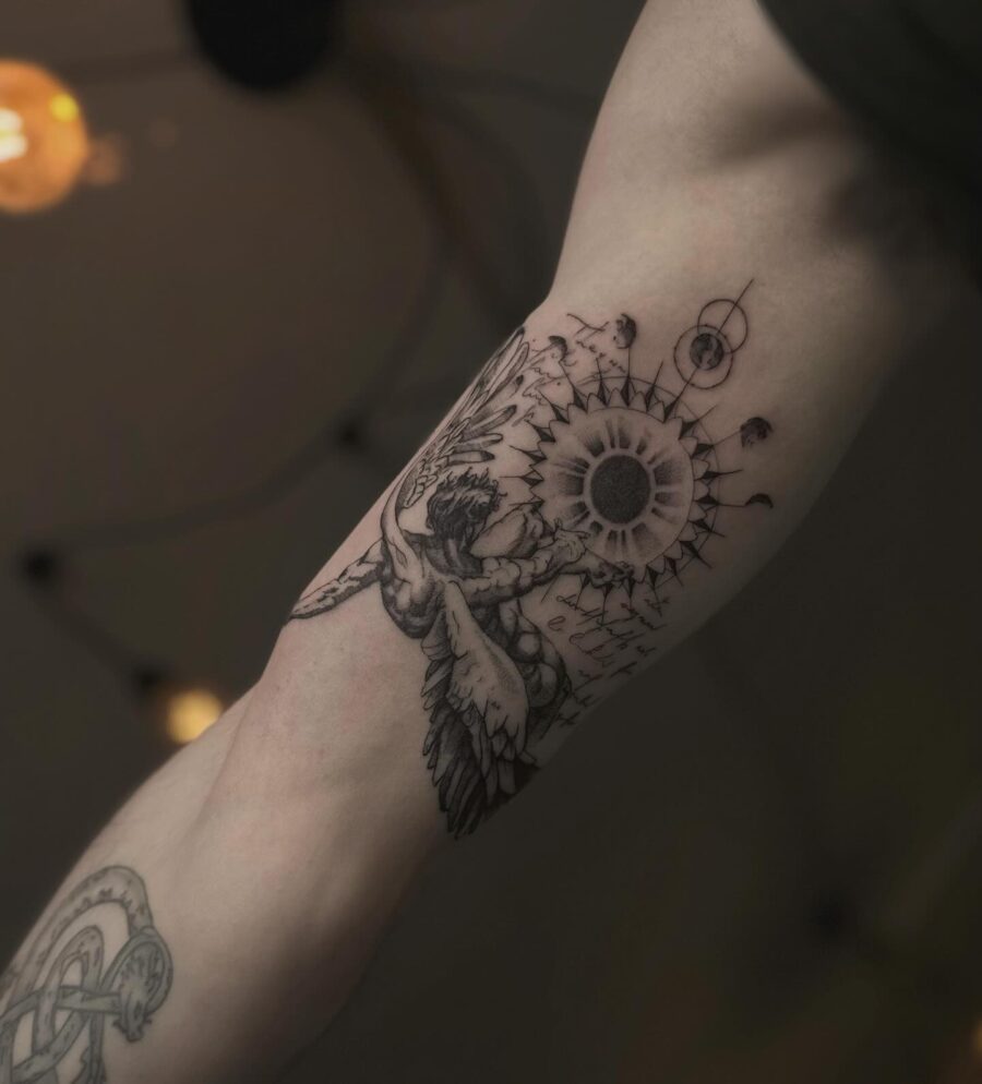 Intricate design of sun and wings tattoo