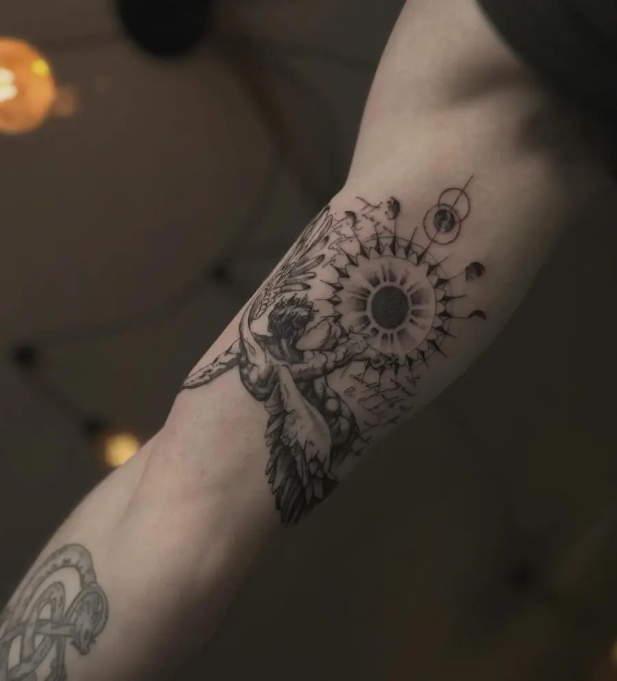 Intricate design of sun and wings tattoo