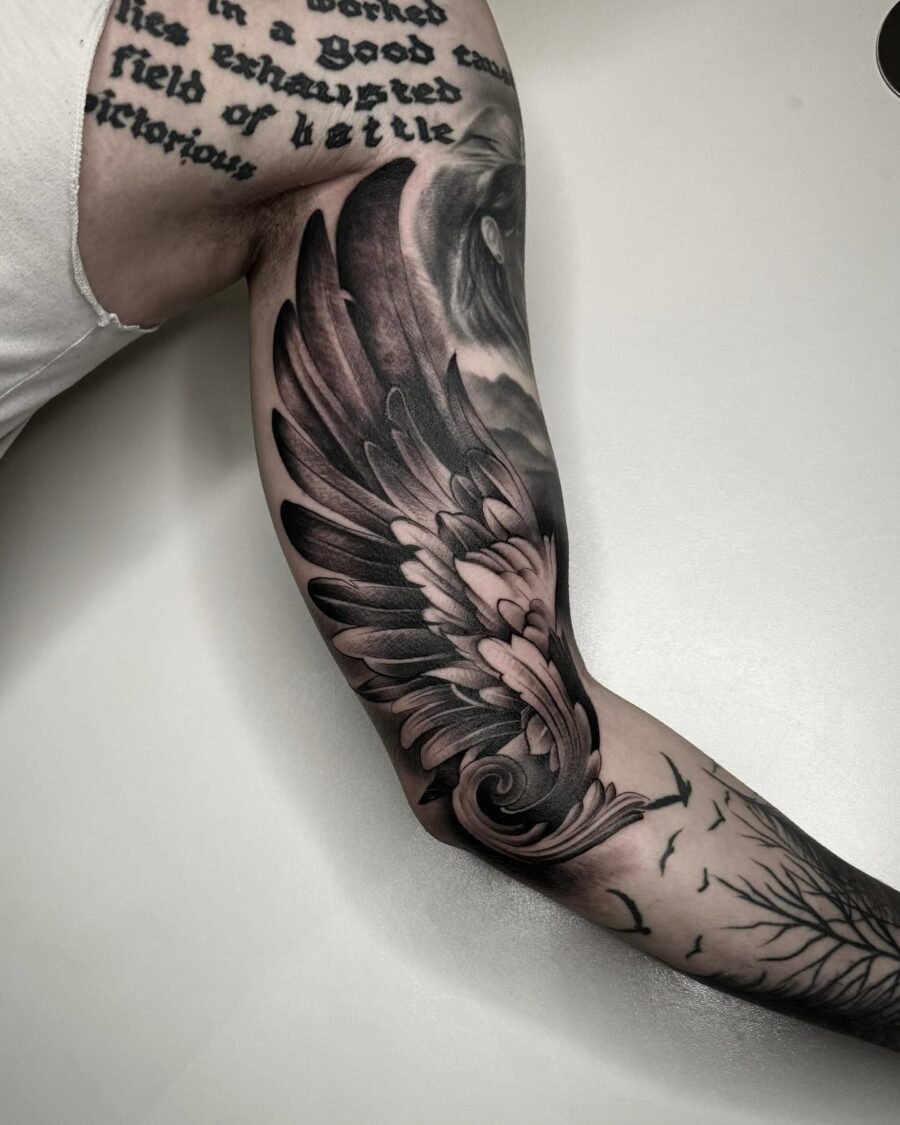 Intricate wing design on bicep tattoo