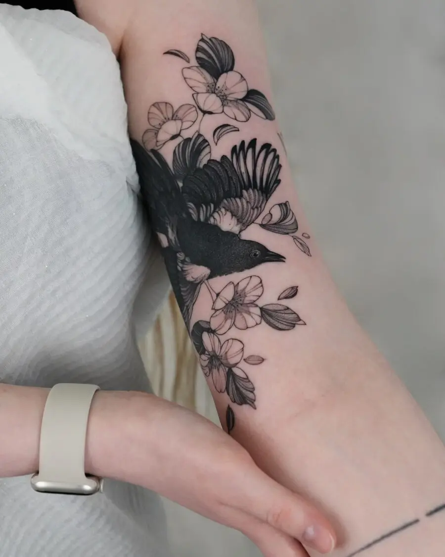 Elegant bird tattoo with floral elements