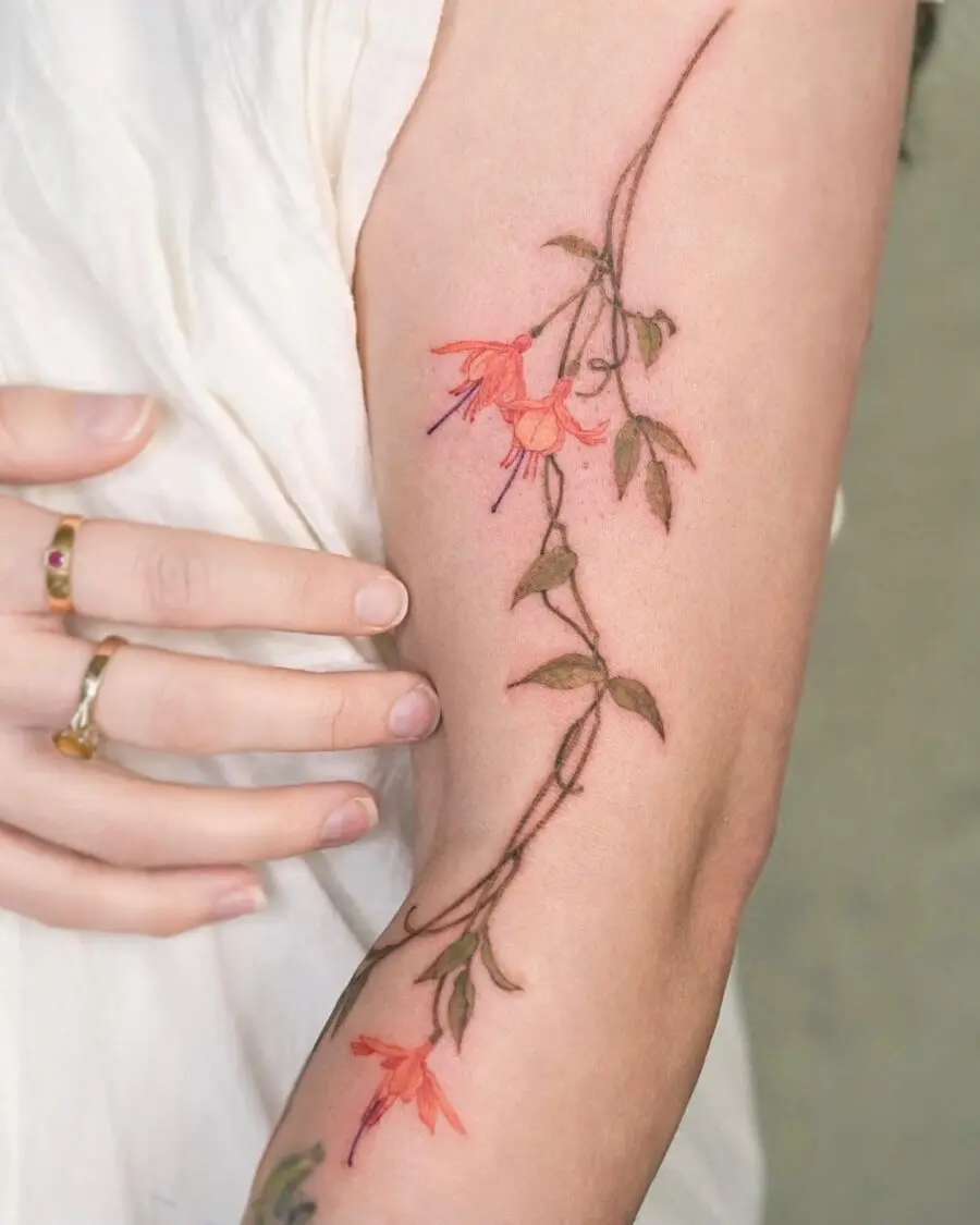 Elegant fuchsia flower tattoo on the arm