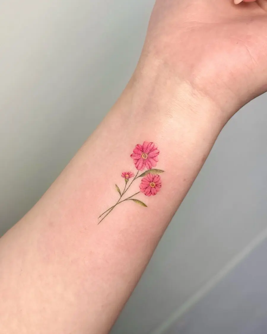 Delicate pink flower tattoo on the arm