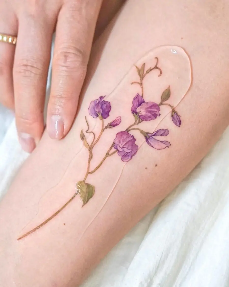 Delicate purple flower tattoo on the arm