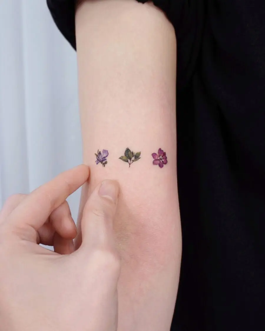 Elegant purple flower tattoos on the arm