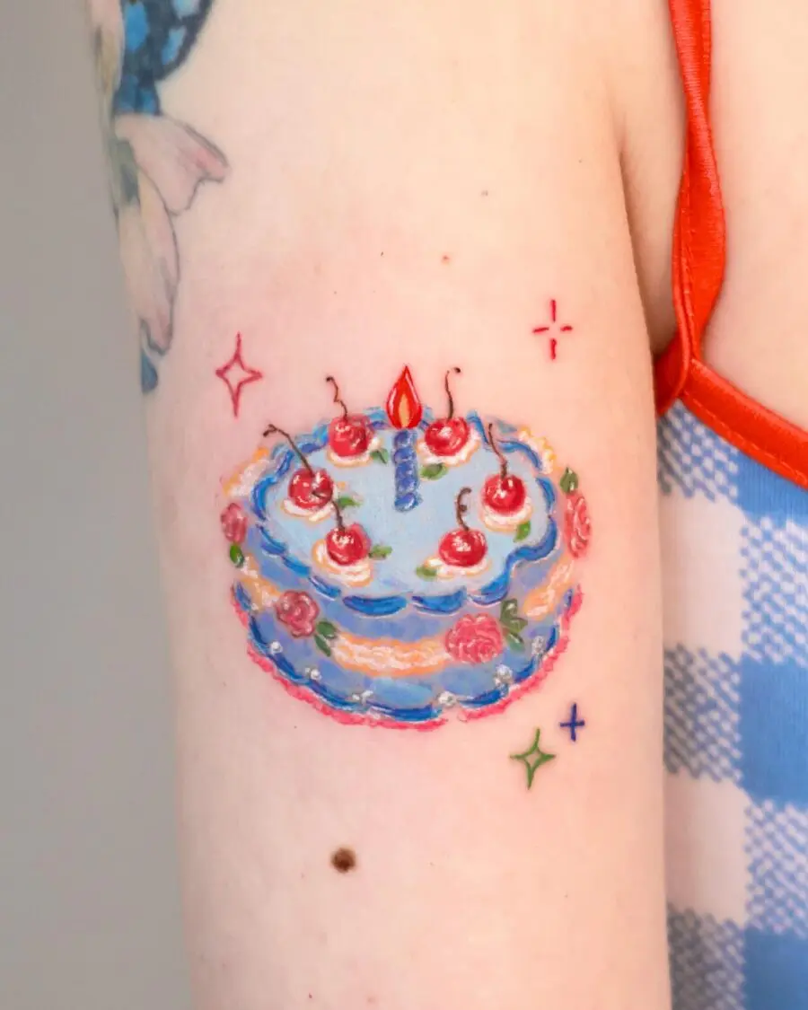Vibrant birthday cake tattoo design with cherries