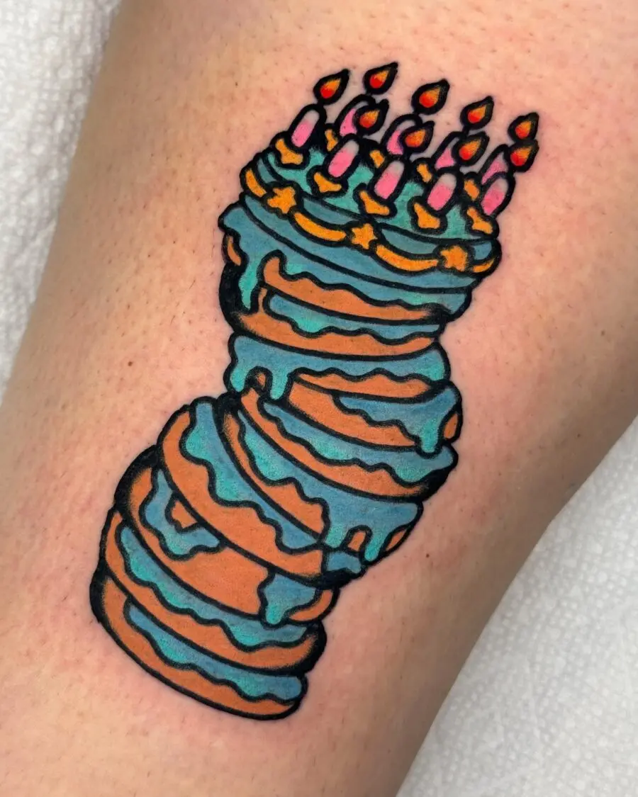 Whimsical birthday cake tattoo with candles