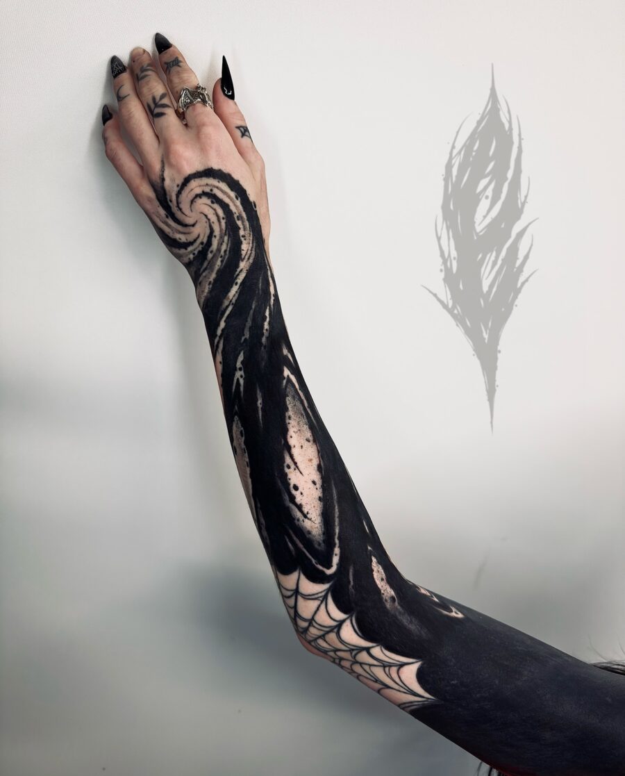 Intricate black sleeve tattoo with swirling design