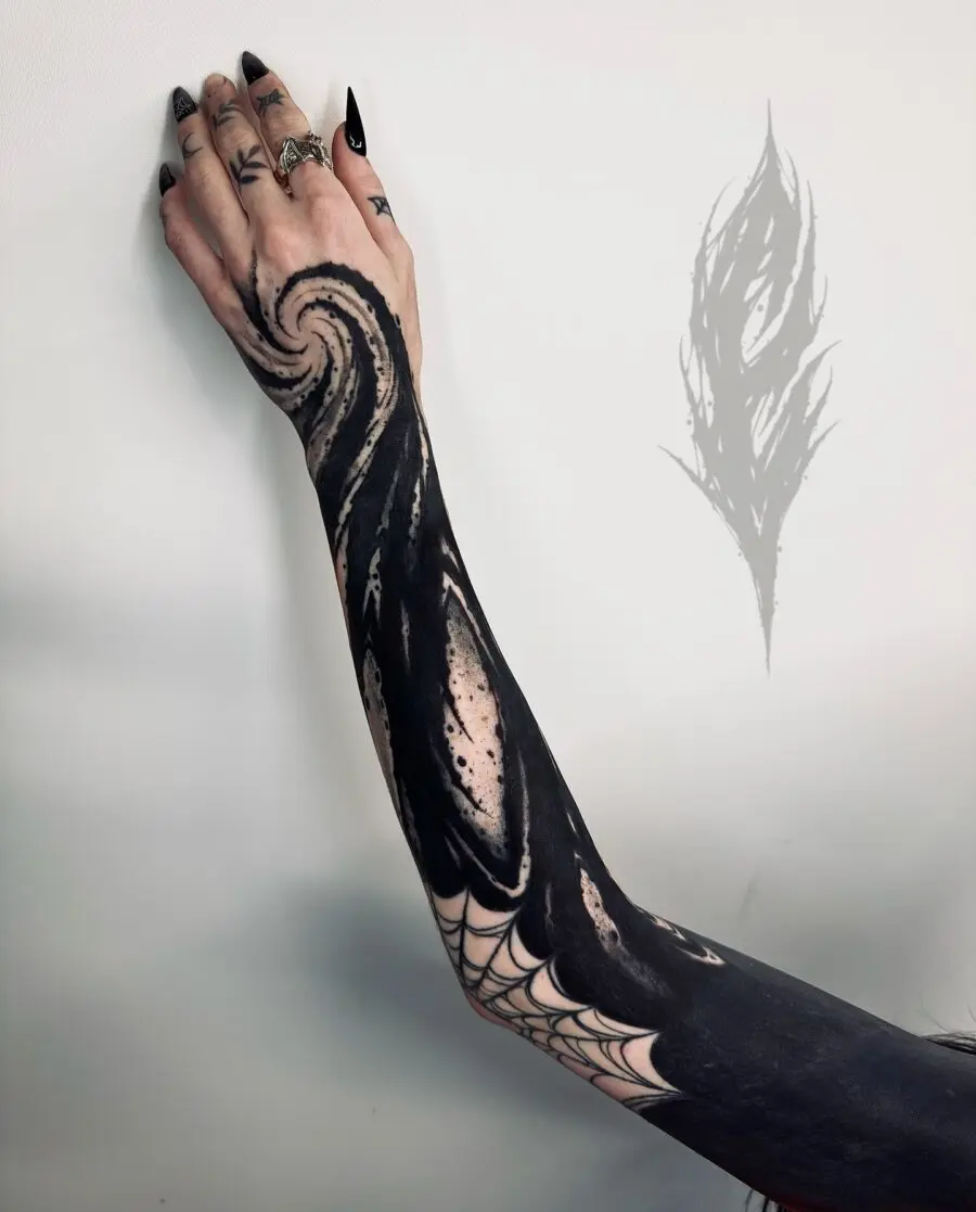 Intricate black sleeve tattoo with swirling design