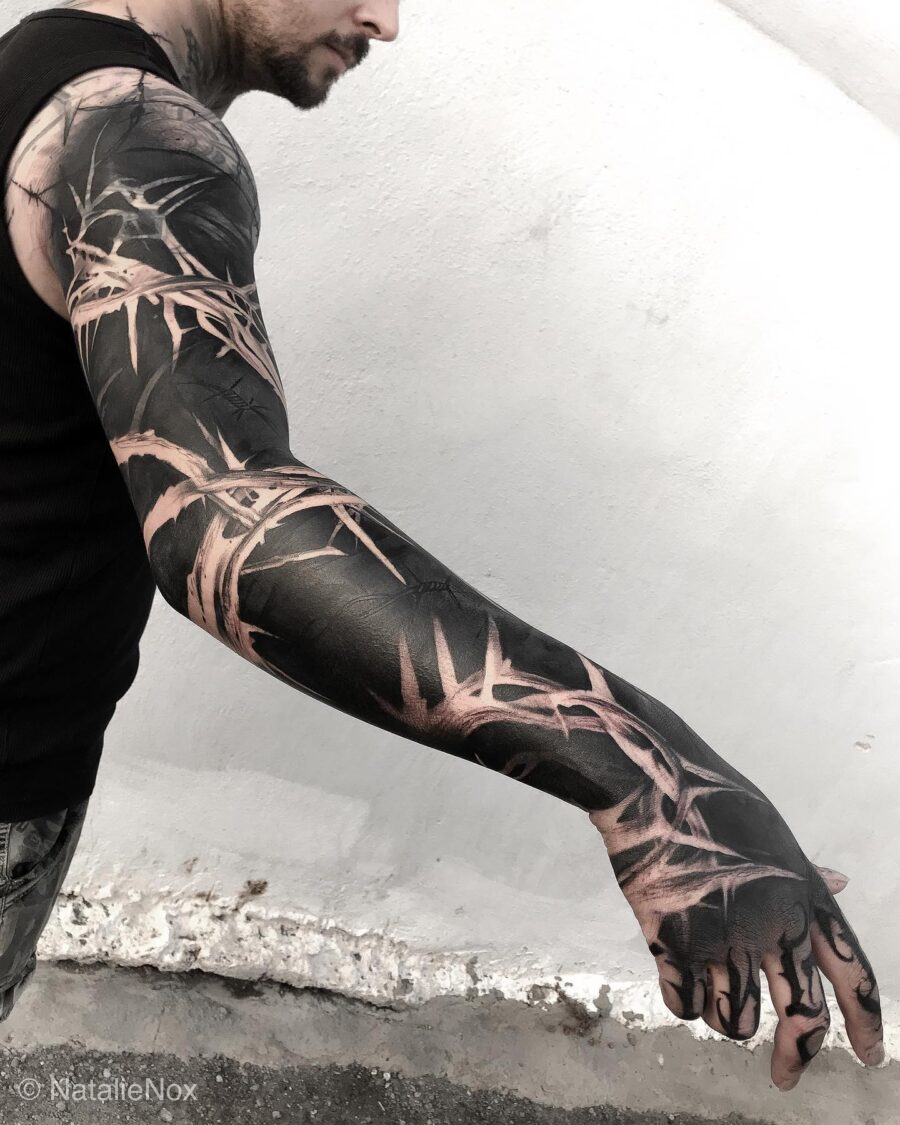 Bold black bamboo-inspired sleeve tattoo design